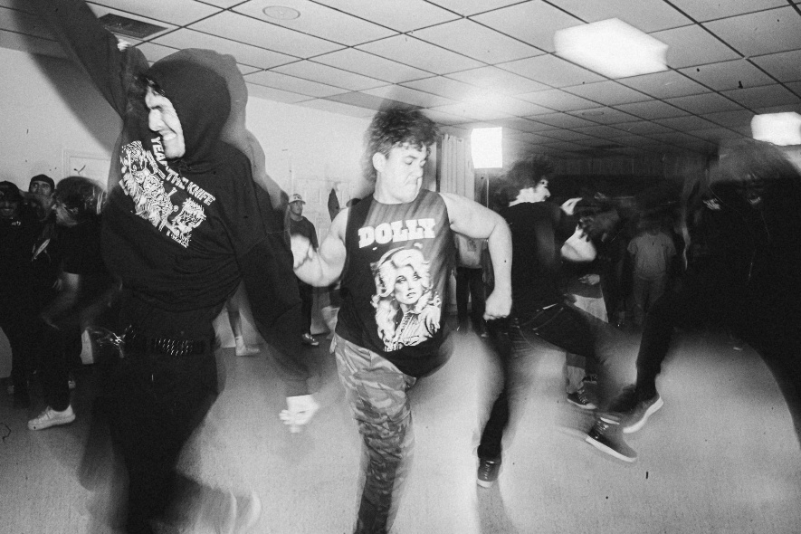 party in a punk scene, wearing vintage rock music shirts dancing